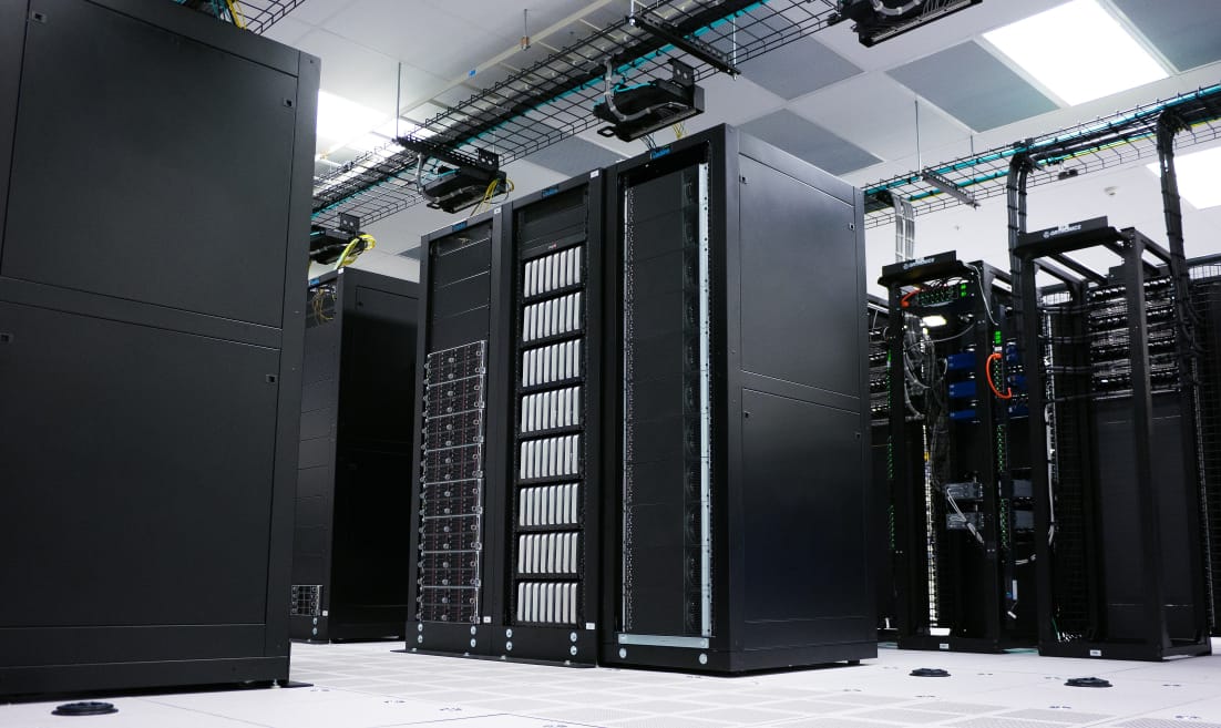 Large server room with black equipment and racks.