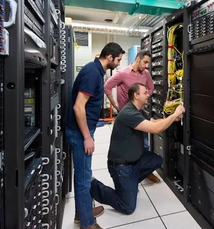 Two technicians maintaining server in data center.